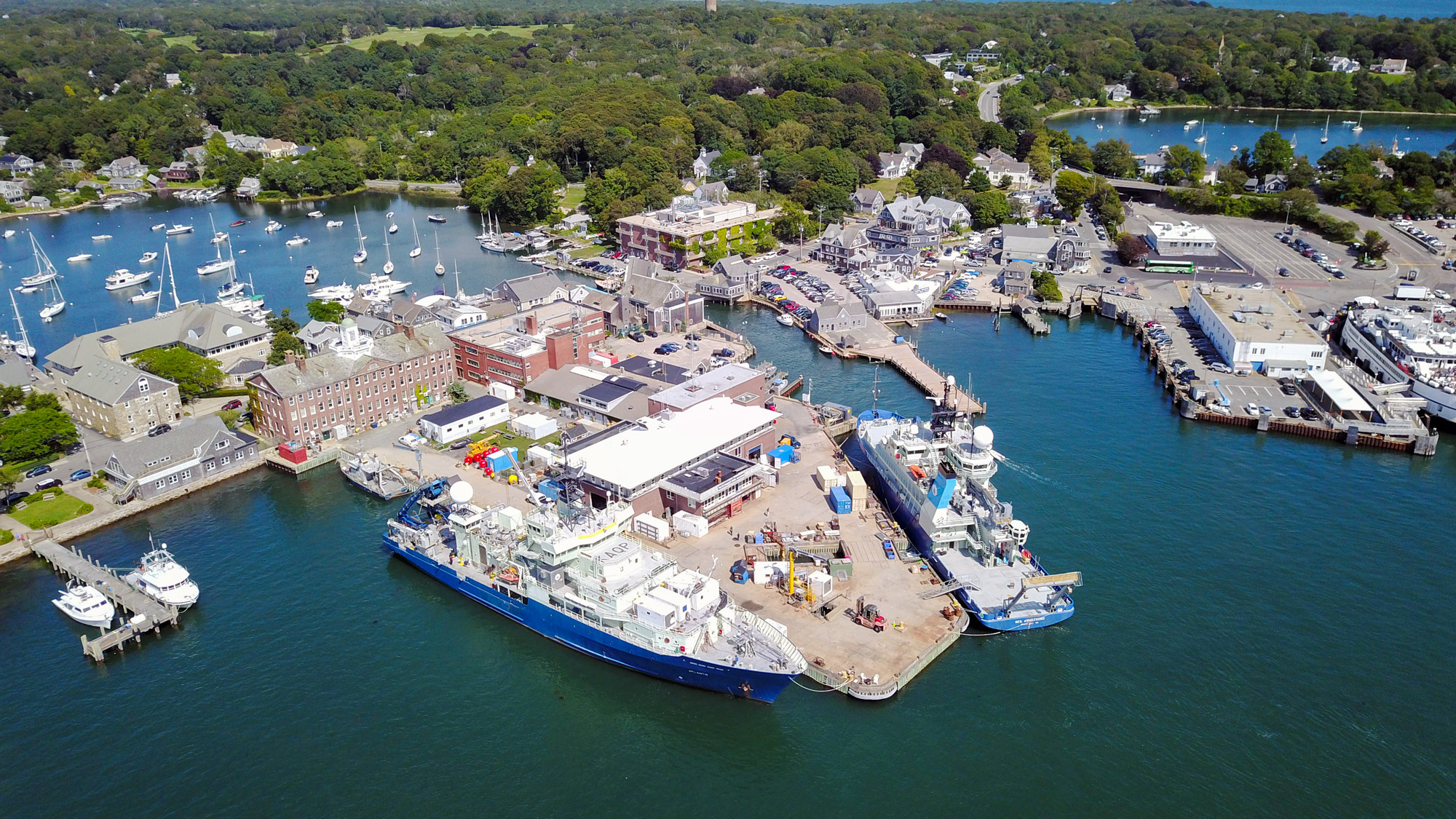 Aerial of Woods Hole village and the WHOI dock with three vessels.
